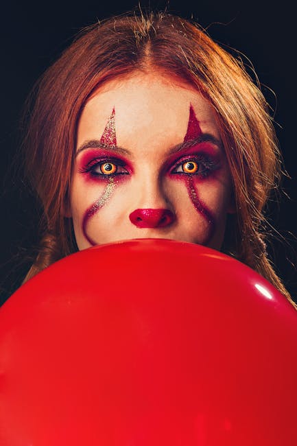 Portrait of a woman with clown makeup holding a red balloon. Halloween vibe.